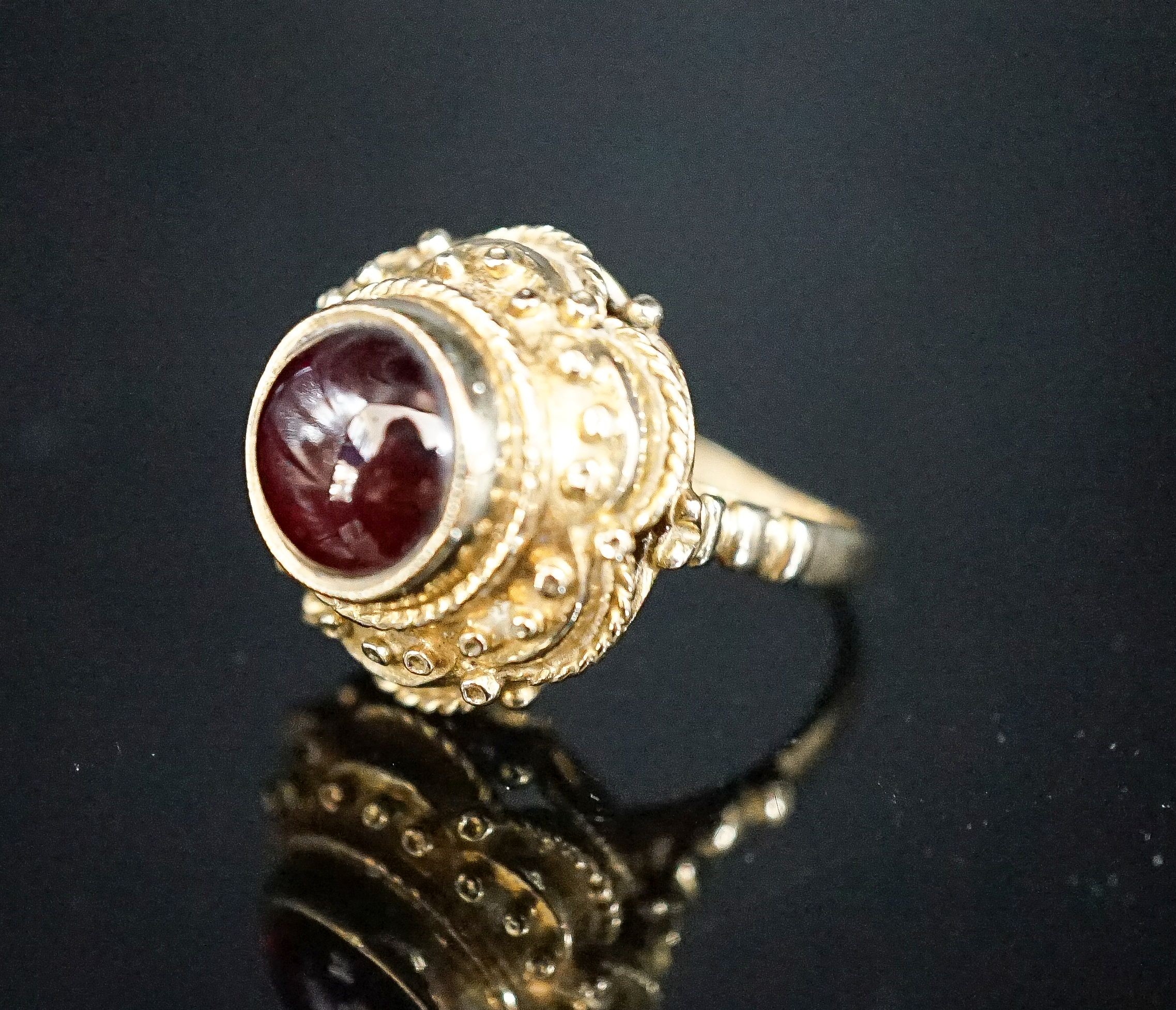 A 1960's Victorian style 9ct gold and cabochon garnet set dress ring, size I, gross 7.2 grams.